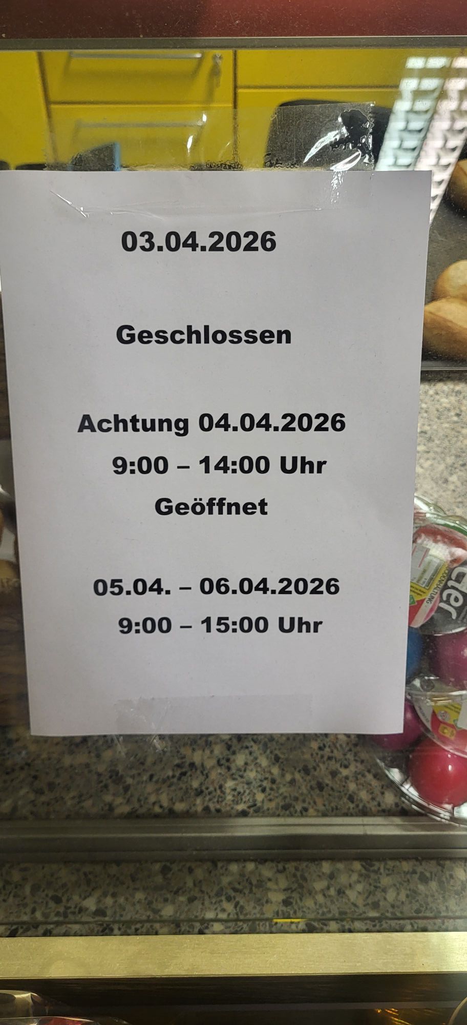 Ein Schild in der Vitrine gibt die Öffnungszeiten an: Am 03.04.2026 geschlossen, am 04.04.2026 von 9 bis 14 Uhr und vom 05.04. bis 06.04.2026 von 9 bis 15 Uhr geöffnet